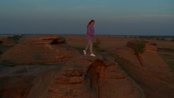 A Girl Does Fitness on a Hill at Sunset
