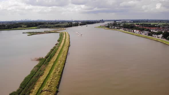 High Aerial View Of River Noord With Inland Cargo Ship Travelling Along. Dolly Forward, Establishing alt