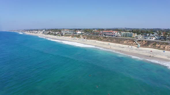 Drone shot flying over the sea towards Carlsbad State Beach in California, USA alt