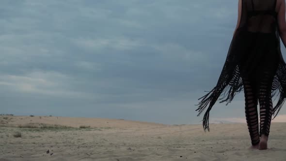 Woman in Black Walking in Desert