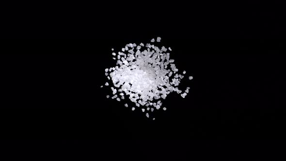 Sea salt exploding against black background. Slow Motion. alt