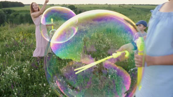 Large Soap Bubbles Burst Hitting the Grass alt