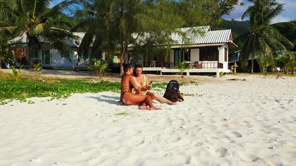 Tourists posing on relaxing tourist beach lifestyle by shallow ocean and white sand background of Th alt