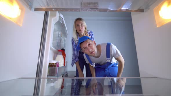 The refrigerator repairman opens the door and the list of works alt