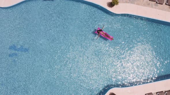 Topdown Shot of Woman on Pink Floatie with the Pool All to Herself alt