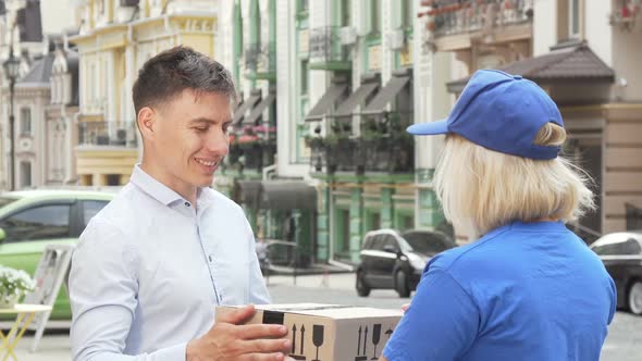 Handsome Man Examining Package Delivered By Female Courier
