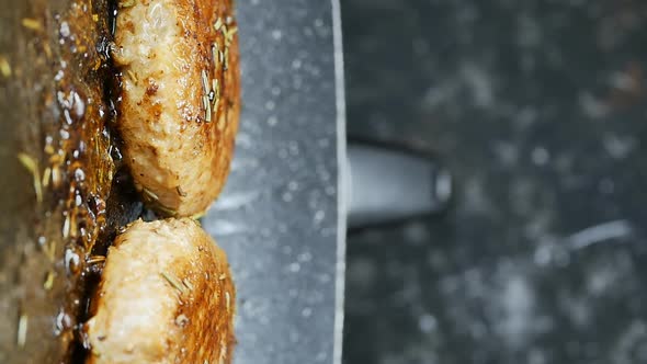 Vertical Shot Two Golden Delicious Cutlets Fry in a Pan with Sauce and Spices alt