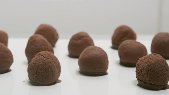 Chocolate truffles on a conveyor belt at candy factory