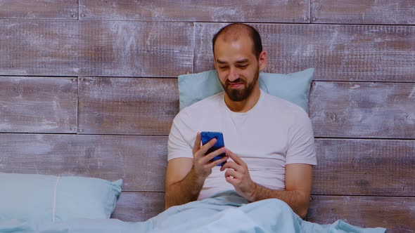 Man Using Phone and Looking at Social Media Content alt