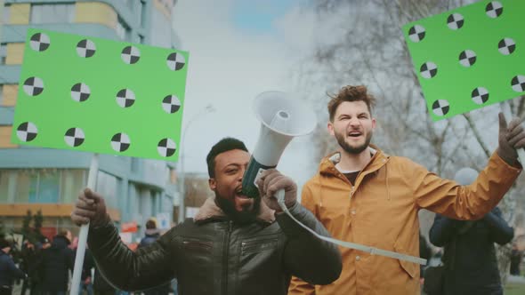 Black African with White Man with Mockup Placards and Bullhorns at Demonstration alt