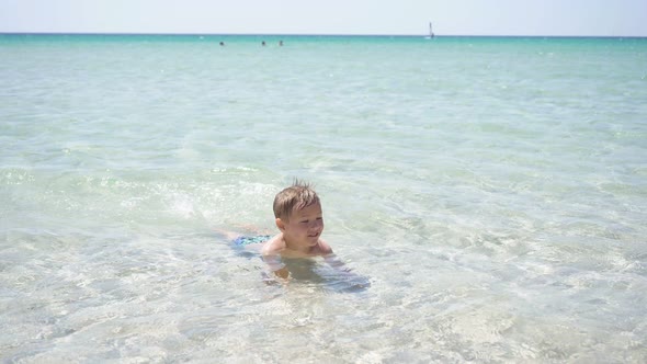 Cute Boy Swimming in the Crystal Clear Sea on a Sunny Summer Day