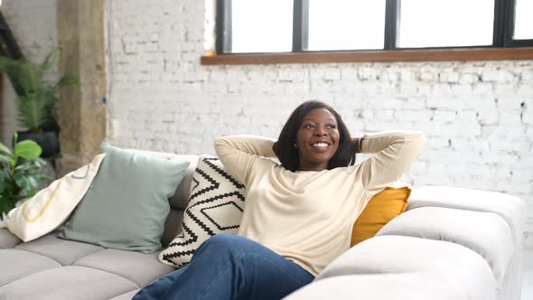 Joyful Full of Energy Woman in Casual Clothes Resting on the Sofa