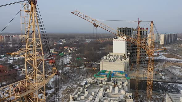 A Close-up View From the Air on the Construction Cranes. Construction of a Brick House