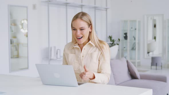 Successful woman typing on laptop in white room. Young woman receiving good news message alt