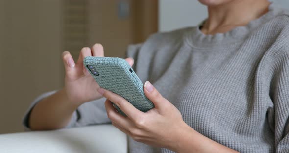 Woman use of mobile phone at home alt