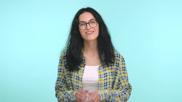 Attractive Woman with Long Curly Hair and Glasses Sighing with Heartfelt Smile Holding Hands Pressed alt