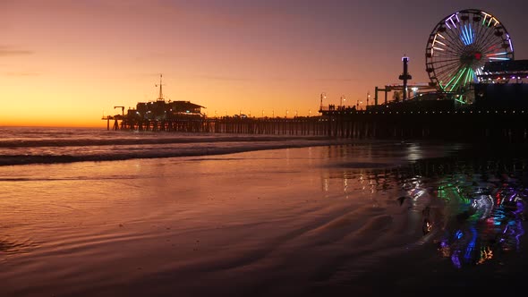 Twilight Waves Against Classic Illuminated Ferris Wheel, Amusement Park on Pier in Santa Monica alt