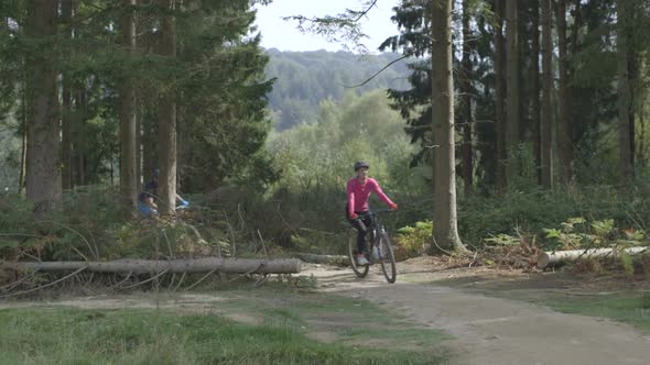 Couple cycling through forest Tracking Left