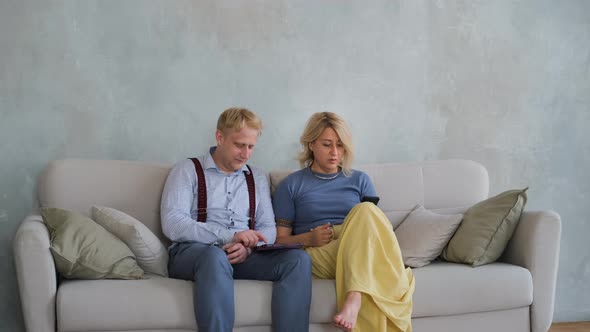 Mother with Adult Son Using Tablet PC on Sofa