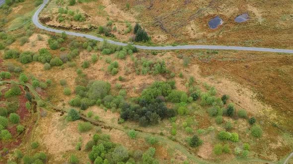 Topdown revealing drone shot of cloudy scottish highland valley mountains alt