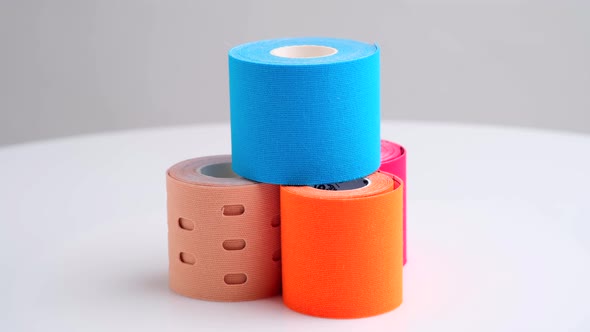 Rotating Stack of Kinesiology Tape for Athletes on White Background alt