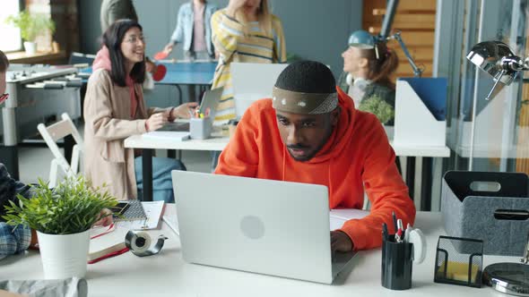 Joyful AfroAmerican Businessman Sharing Good News with Colleagues Laughing Doing Highfive Expressing alt