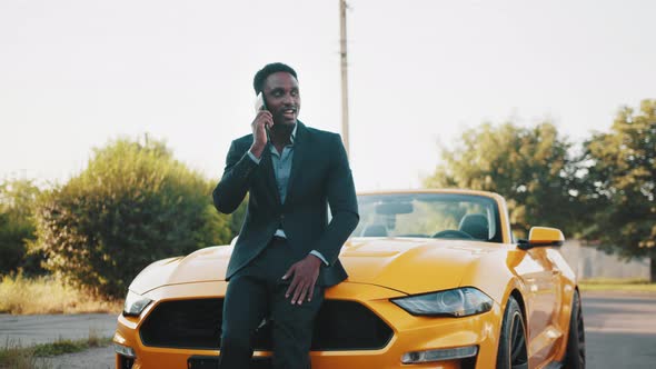 Confident African Man in Business Suit Standing Near Luxury Car with Modern alt