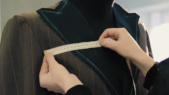 Tailor Taking Measures with Measuring Tape on a Mannequin alt