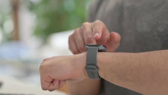 Hands of Young Man Using Smartwatch Close Up alt