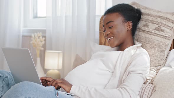 Happy African American Girl Pregnant Woman Ethnic Black Expectant Mother Uses Laptop to Communicate alt