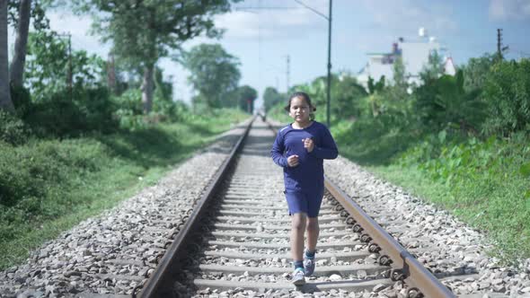 Indian Kid Running on the Railway Track in the Himalayan Range of India Greenery in the Background