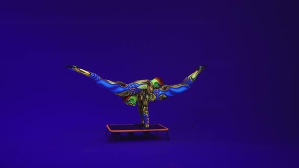 Twins Acrobats Perform A Pair Of Gymnastic Elements On A Blue Cyclorama,Neon Makeup And Costumes alt