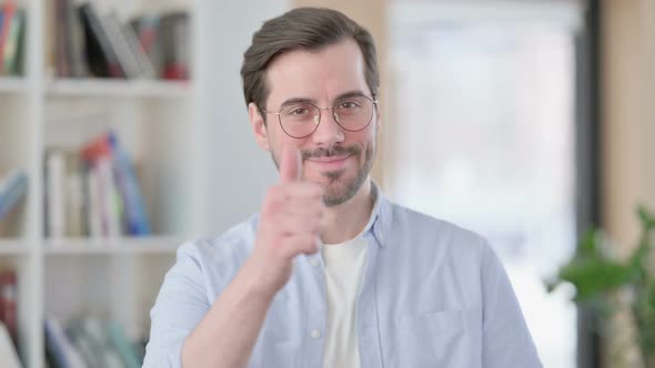 Portrait of Man in Glasses Showing Thumbs Up Sign alt