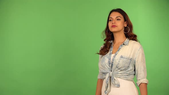 A Young Caucasian Woman Shades Her Eyes and Looks Off Into Distance with a Smile  Green Screen