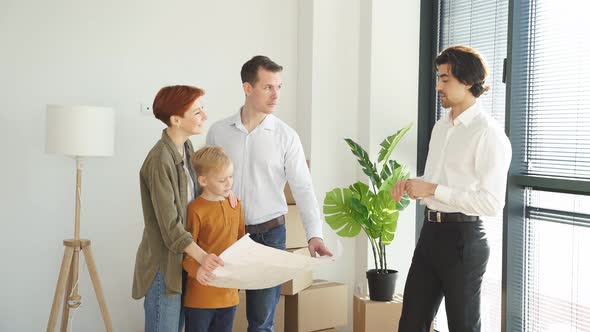 Caucasian Family Talking with Real Estate Agent While Analzying Housing Plans During Meeting