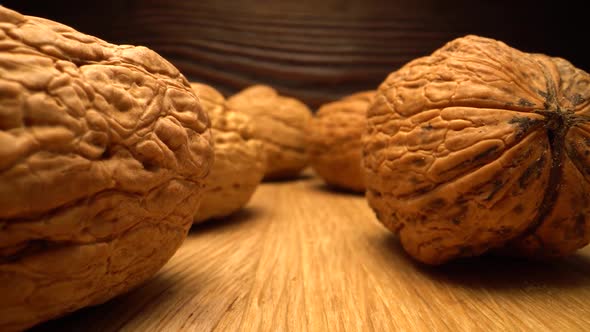 Walnut Close Up on a Wooden Table. Vertical Sliding Camera Moving Through Nut. Laowa Probe Lens. alt
