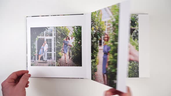 Hands Flipping Through Photobook From Photo Shoots of a Beautiful Happy Couple alt