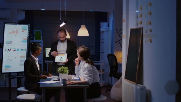 Workaholic Overworked Businessman Explaining Company Strategy Using Tablet for Presentation alt