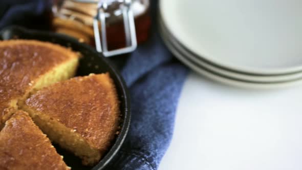 Slice of sweet cornbread with honey on the plate alt
