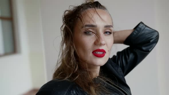 Attractive Woman with Red Lips is Looking at Camera and Playing with Hair alt