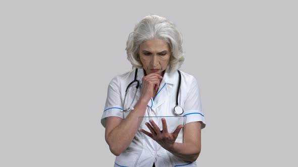 Serious Senior Female Doctor with Glass Mockup Tablet Pc Device alt