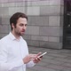Young Man Texting Messages Cheating on His Smartphone While Walking in Office District - VideoHive Item for Sale