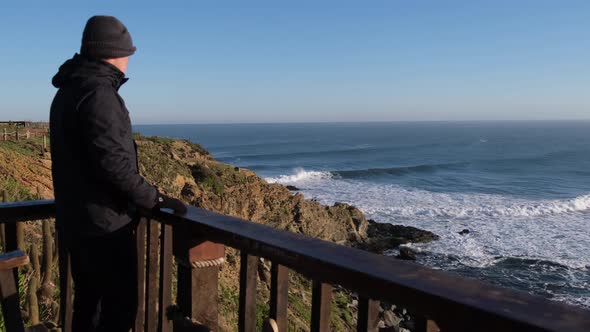 traveler man looking at the sea in pichilemu punta de lobos chile, sunrise cold perfect waves alt