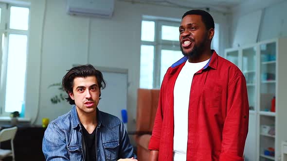 Italian or Indian Teacher Practicing Vocal Cords with African American Man in Class Day Time alt