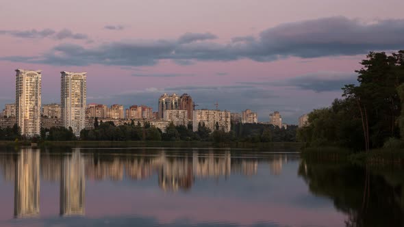 High Rise Buildings Of The City Near A Calm River, Timelapse