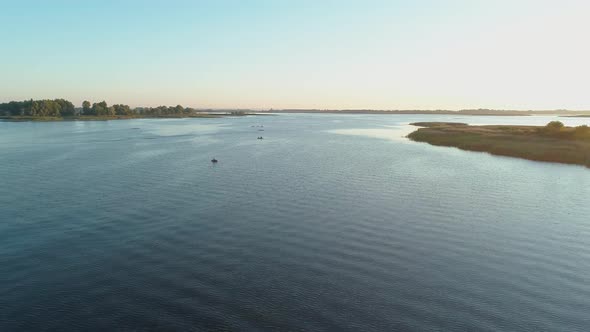 Aerial Drone Footage. Backward Fly Over River with Islands at Sunrise
