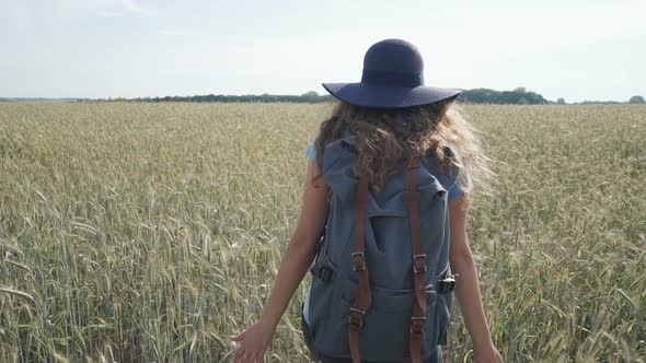 Woman Traveler Walking in the Field With Spikelets
