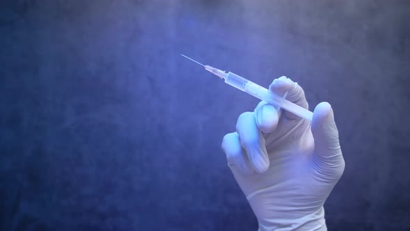 Doctor Hand in Medical Gloves Holding Syringe