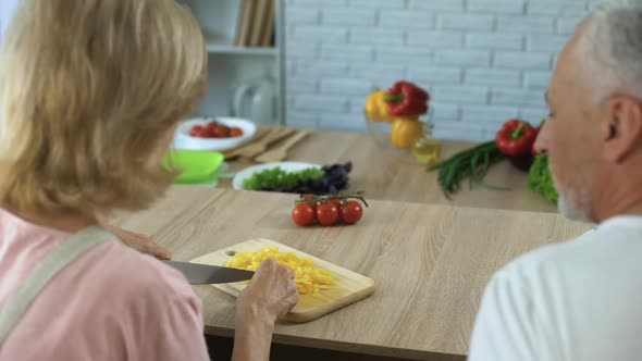 Senior Couple Flirting While Cooking Dinner in Home Kitchen, Happy Family alt