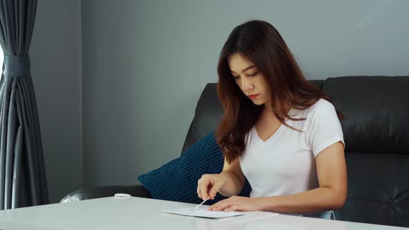 woman using coronavirus(covid-19) rapid antigen self test kit (atk) at home with a cotton nasal swab alt